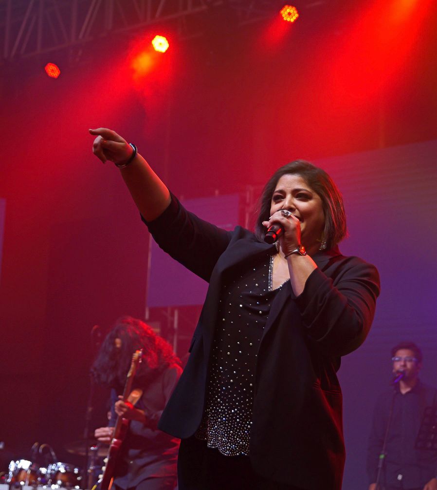 Vasundhara Das commanding the stage under red lights.