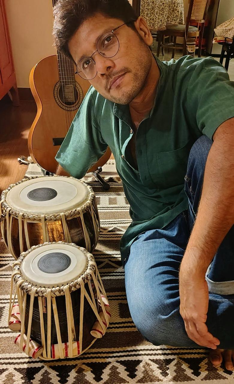 Anurag with tabla and acoustic guitar at home.
